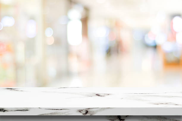 istock Empty white marble table over blur store background, product and food display montage 669423138