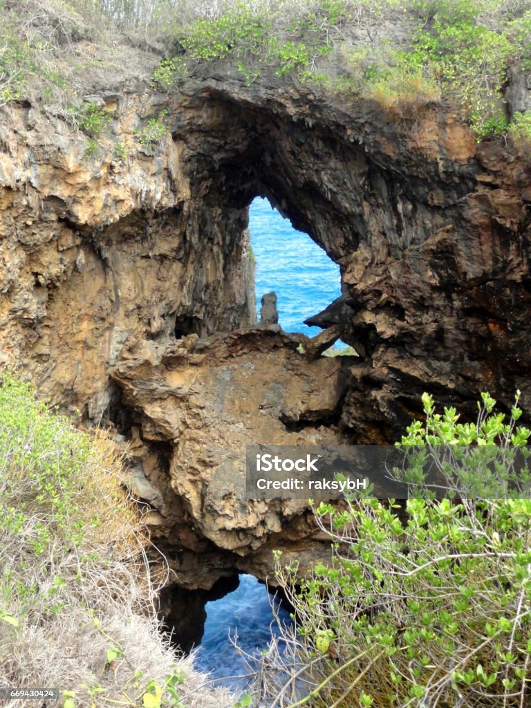 Double Grotto, Saipan A double grotto above the Old Man by the Sea in the jungles of Saipan is one destination that not everyone knows about. Cliff Stock Photo