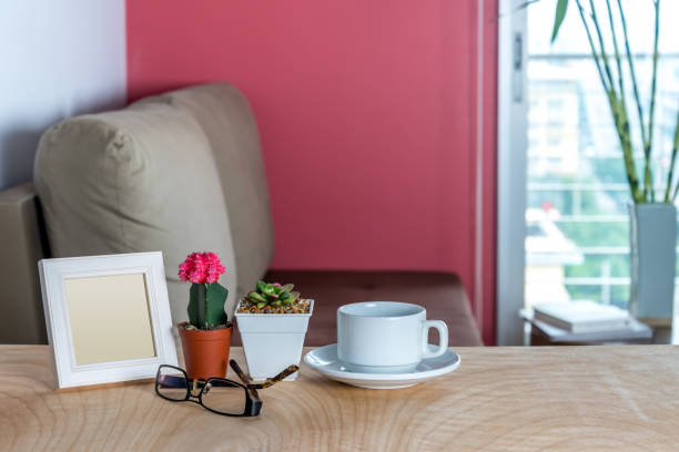 istock Photo frame, cactus, succulent pots & coffee cup decoration on wooden table 669433888