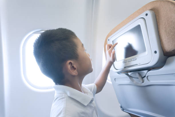 istock Young boy touching tv screen in airplane 669438522