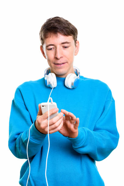 istock Studio shot of man wearing headphones around neck while using mobile phone 669441336