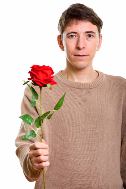 istock Studio shot of man holding red rose against white background 669441480