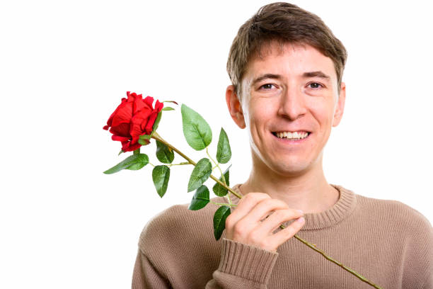 istock Close up of happy man smiling while holding red rose 669441484