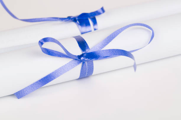 istock Rolled diploma or paper with blue ribbon 669445238