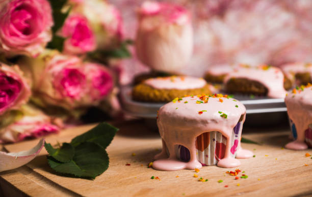 istock Cupcake with pink glaze on the wooden background 669447678