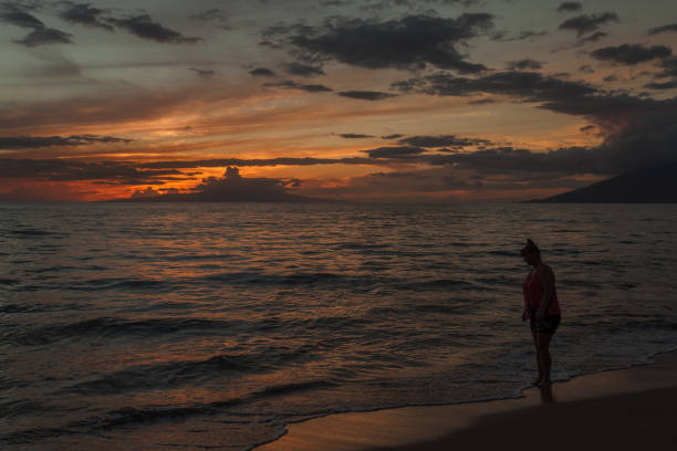 istock Woman walking at the beach at Sunset 669452370