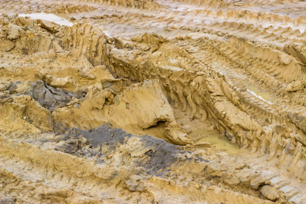 istock Tire tracks on the ground and puddles, background 669452372