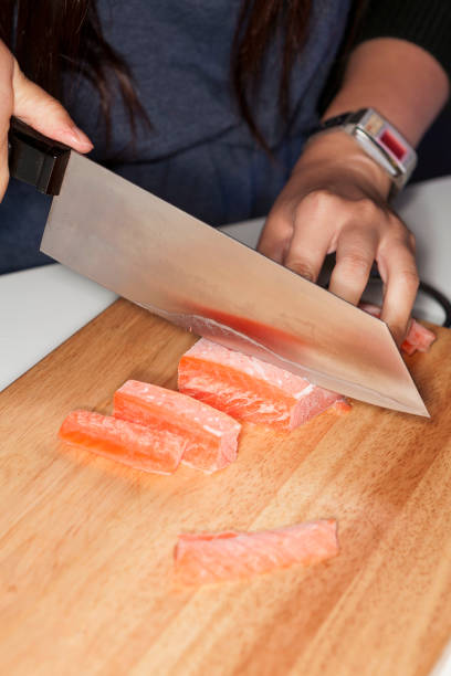 istock Hand using knife cutting freeze salmon meat 669455876