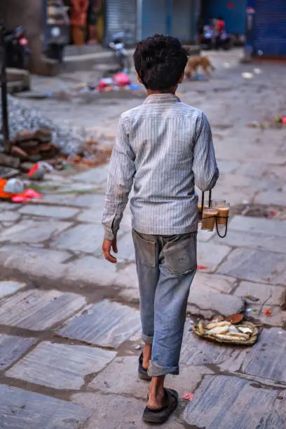 Photo of Indian little boy selling chai on streets of Kathmandu, Nepal