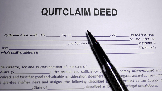 Someone filling out Quitclaim Deed Form used to transfer interest in real property.