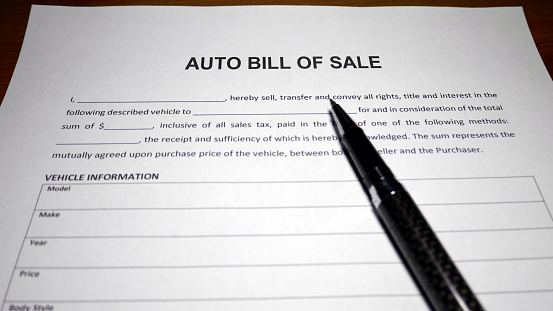 Someone filling out Auto Bill of Sale.