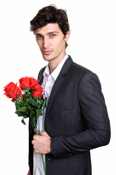 istock Studio shot of young handsome businessman holding red roses while looking at camera 669459800