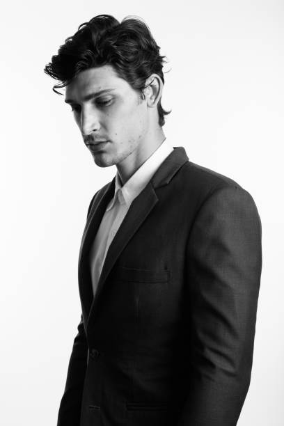 istock Studio shot of young handsome businessman thinking while looking down in black and white 669459954