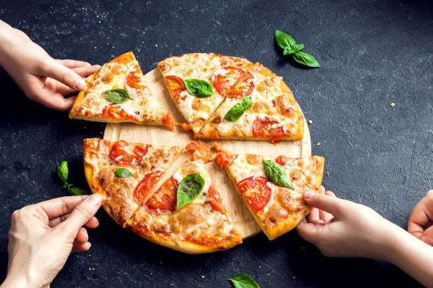 Taking Slice Of Pizza People Hands Taking Slices Of Pizza Margherita. Pizza Margarita and  Hands close up over black background. mozzarella photos stock pictures, royalty-free photos & images
