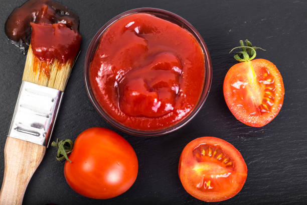 istock Bowl with  ketchup, tomatos  and brush on black stone backgrou 669478056