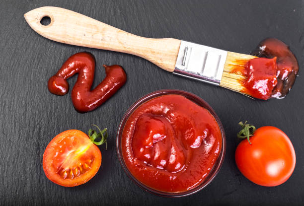 istock Bowl with  ketchup, tomatos  and brush on black stone backgrou 669478086