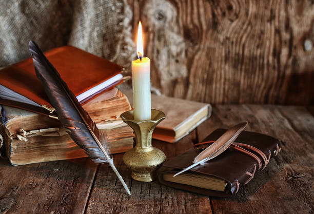istock feather and book novel close to the a candle 669481272