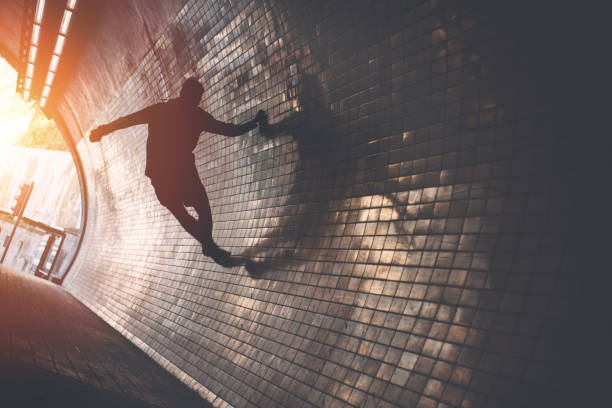 istock Silhouette of man doing wall run in the dark tunnel 669483400