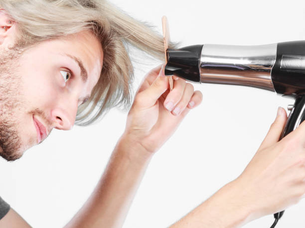 istock Young man drying hair with hairdryer 669483420