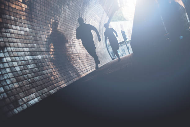 Silhouette of running athletes in tunnel