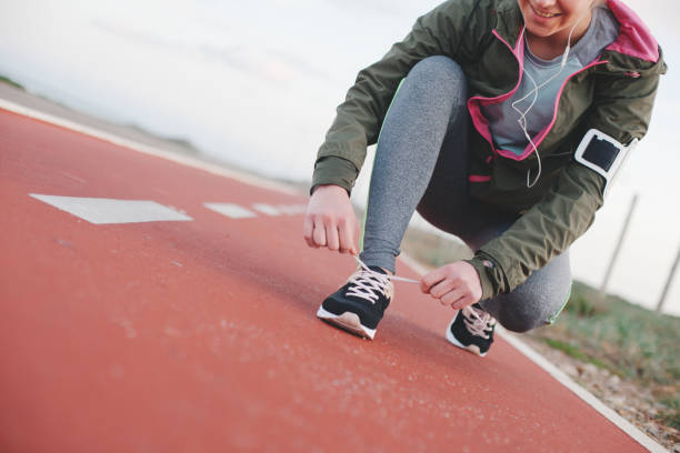 istock Athletic woman tying shoelaces before running 669484048