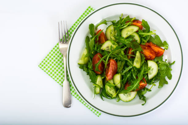 Healthy and diet food: arugula, cucumbers and tomatoes. Studio Photo