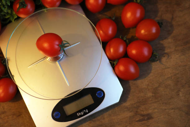 istock Fresh tomatoes on kitchen scales weighing 669495696