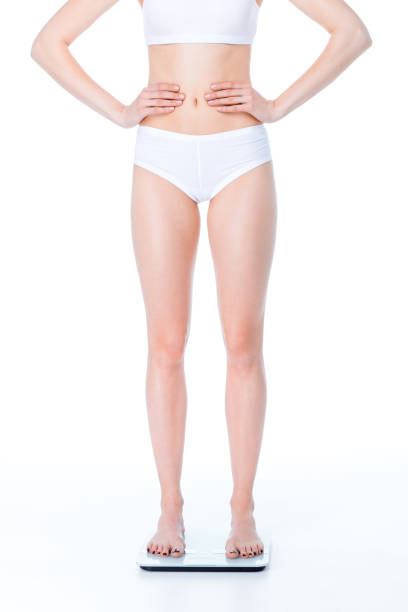 Rear view portrait of slender woman posing in underwear isolated over grey studio background. Slim body shape. Concept of natural beauty, body and skin care, health, spa, wellness, cosmetics, ad