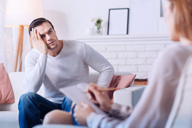 istock Sad depressed man looking at his psychologist 669502176