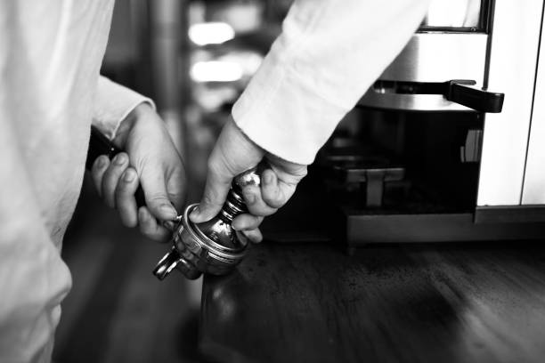 Hand tamping coffee in black and white