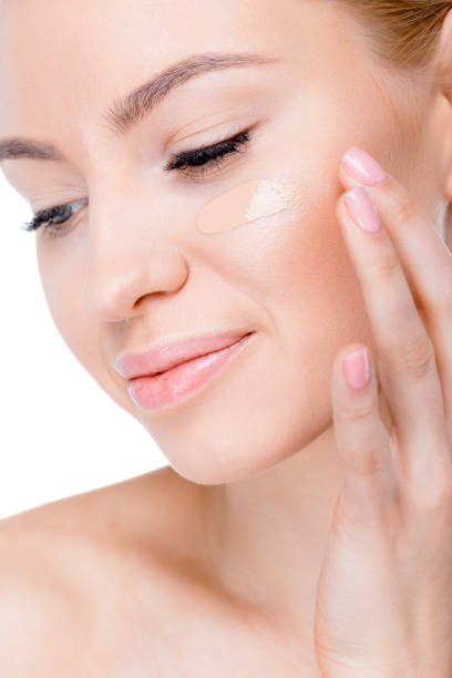 istock woman with foundation cream on face 669506306