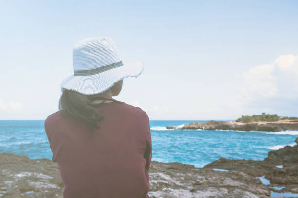 istock Young woman sitting at cliff 669513202