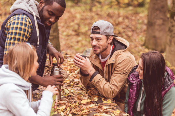 istock Friends pouring hot drink in forest 669516578