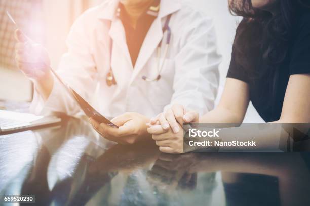 Doctor And Patient Consulting On A Table Stock Photo - Download Image Now - Doctor, Patient, Medical Exam