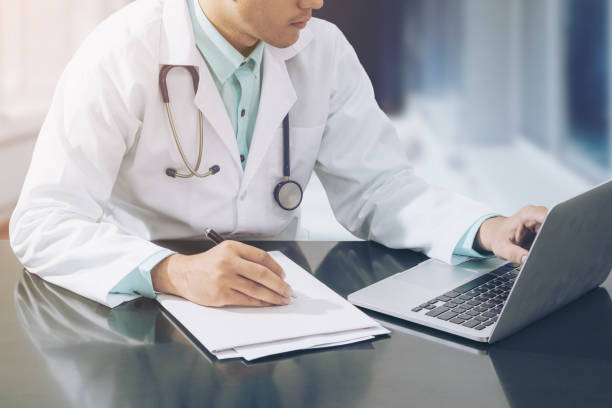 istock Doctor working on desk with laptop 669520262