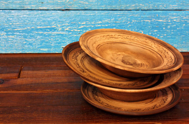 Four round empty brown clay plate bowl with ornament pattern on wooden background. Ukraine
