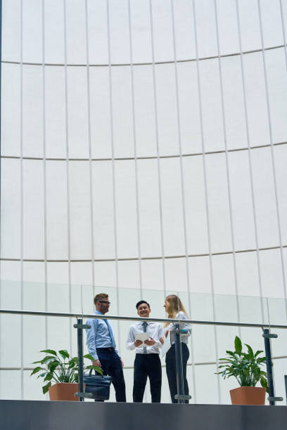 istock Colleagues Chatting Animatedly in Office Lobby 669523828