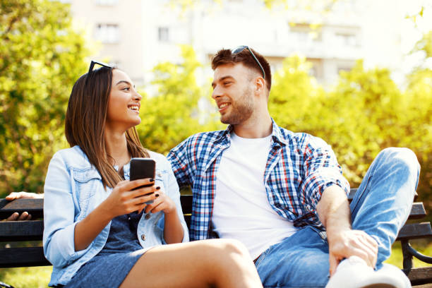 istock Young couple having fun with a smartphone in the park 669524068