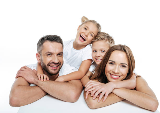 Smiling family in white t-shirts hugging Close-up portrait of smiling family in white t-shirts hugging and looking at camera isolated on white 2000 photos stock pictures, royalty-free photos & images