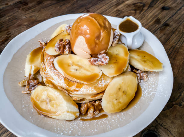 Banana pancakes topped with ice cream, caramel sauce