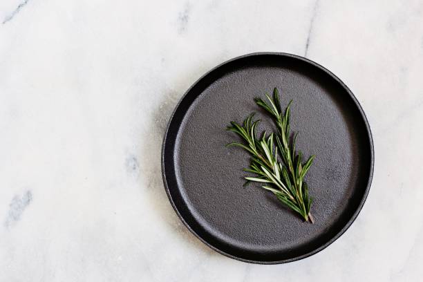 istock Rosemary and cast-iron pan overhead a marble cutting board. 669532756