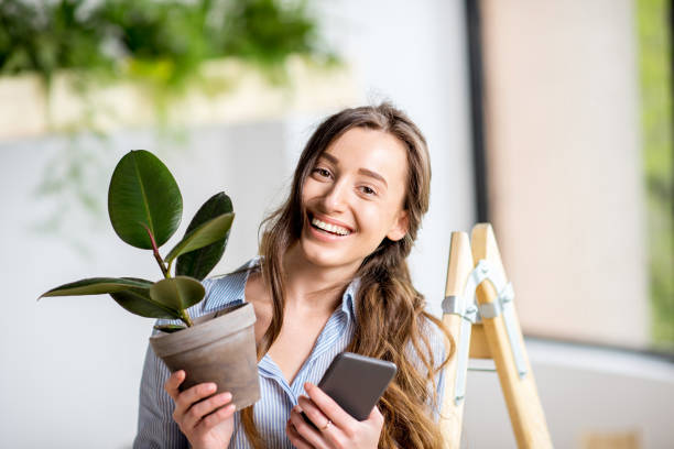 istock Woman with phone and flowerpot 669533194