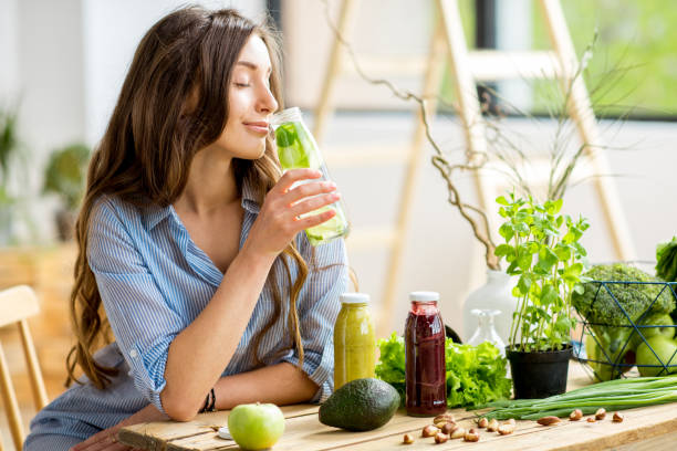 istock Woman with green healthy food and drinks at home 669533708