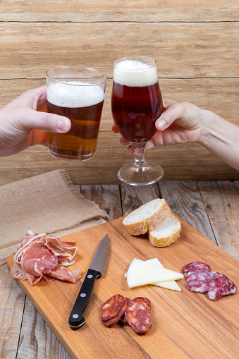 Woman and man toasting with a glass and a glass of beer