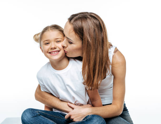 istock Mother hugging and kissing smiling daughter 669534130