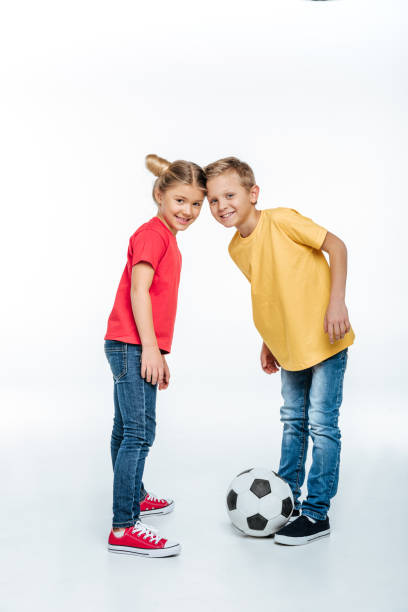 istock siblings standing with soccer ball 669538264