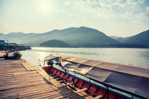 istock Boat in sun light at pier on mountain lake 669548882