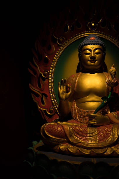 istock Golden Buddha Sculpture on a Dark Background 669555114