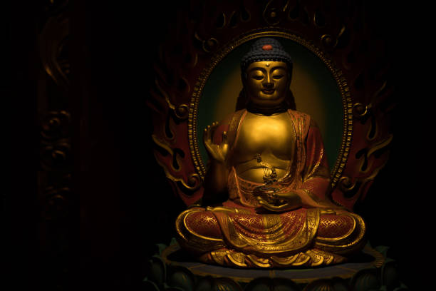 istock Golden Buddha Sculpture on a Dark Background 669555118