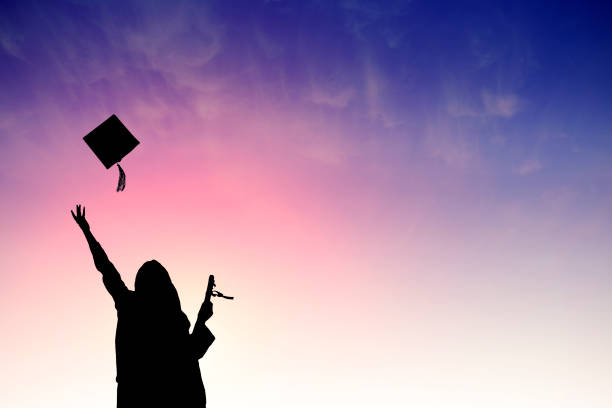 graduados, lanzando para arriba sombreros sobre cielo - graduation student women beauty fotografías e imágenes de stock
